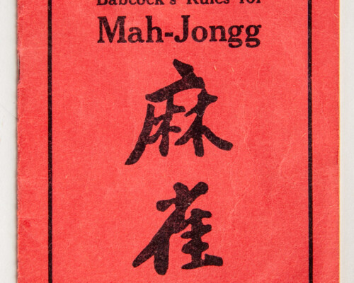 Red Mah-jongg rule book with Chinese text motif and black text.