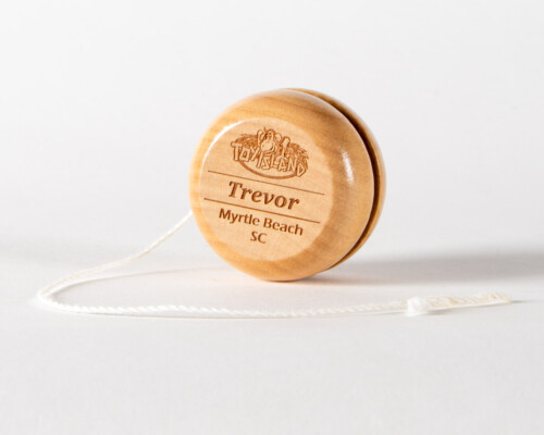 Wooden yoyo with a the words Toy Island, Trevor, and Myrtle Beach SC laser cut in the face.