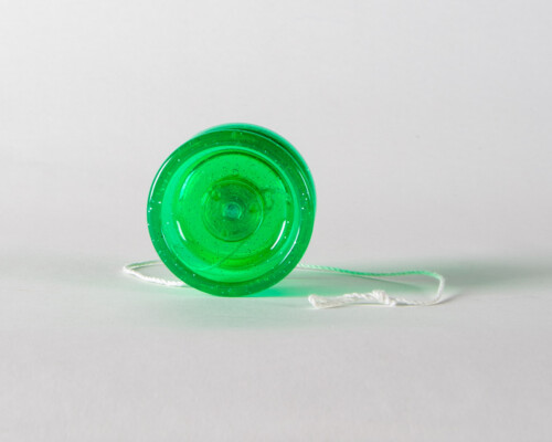 Side view of green polymer yoyo with white string.
