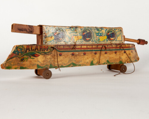 Side of wood and cardboard pull toy shaped like a ship. Painted with naval motifs.