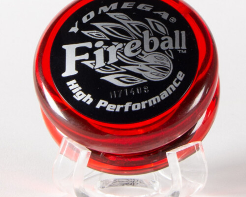 Red "Yomega Fireball" Yo-yo. Silver text on black sticker attached to clear red plastic Yo-yo.