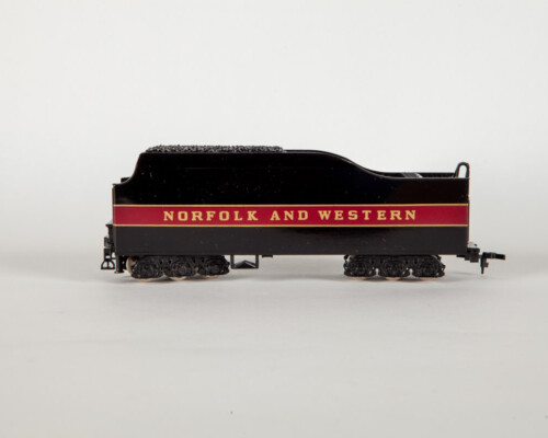 Side view of red and black coal train car. In gold letters it says "Norfolk and Western"