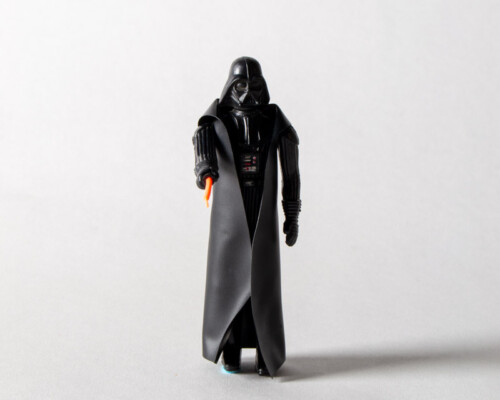 Front view of Darth Vader action figure pointing lightsaber forward.